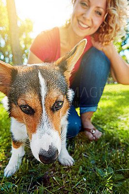 Buy stock photo Shot of a young woman bonding with her dog in the park