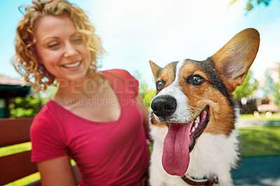 Buy stock photo Shot of a young woman bonding with her dog in the park