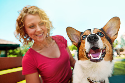 Buy stock photo Shot of a young woman bonding with her dog in the park