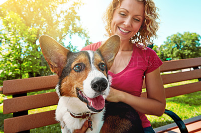 Buy stock photo Shot of a young woman bonding with her dog in the park