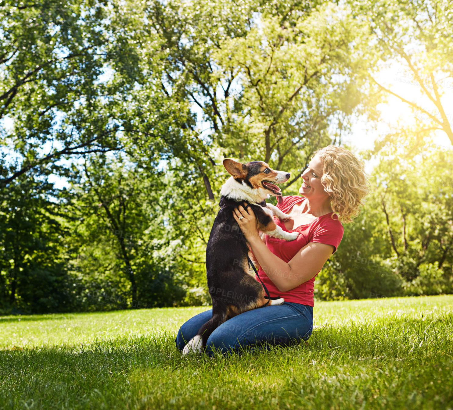 Buy stock photo Shot of a young woman bonding with her dog in the park