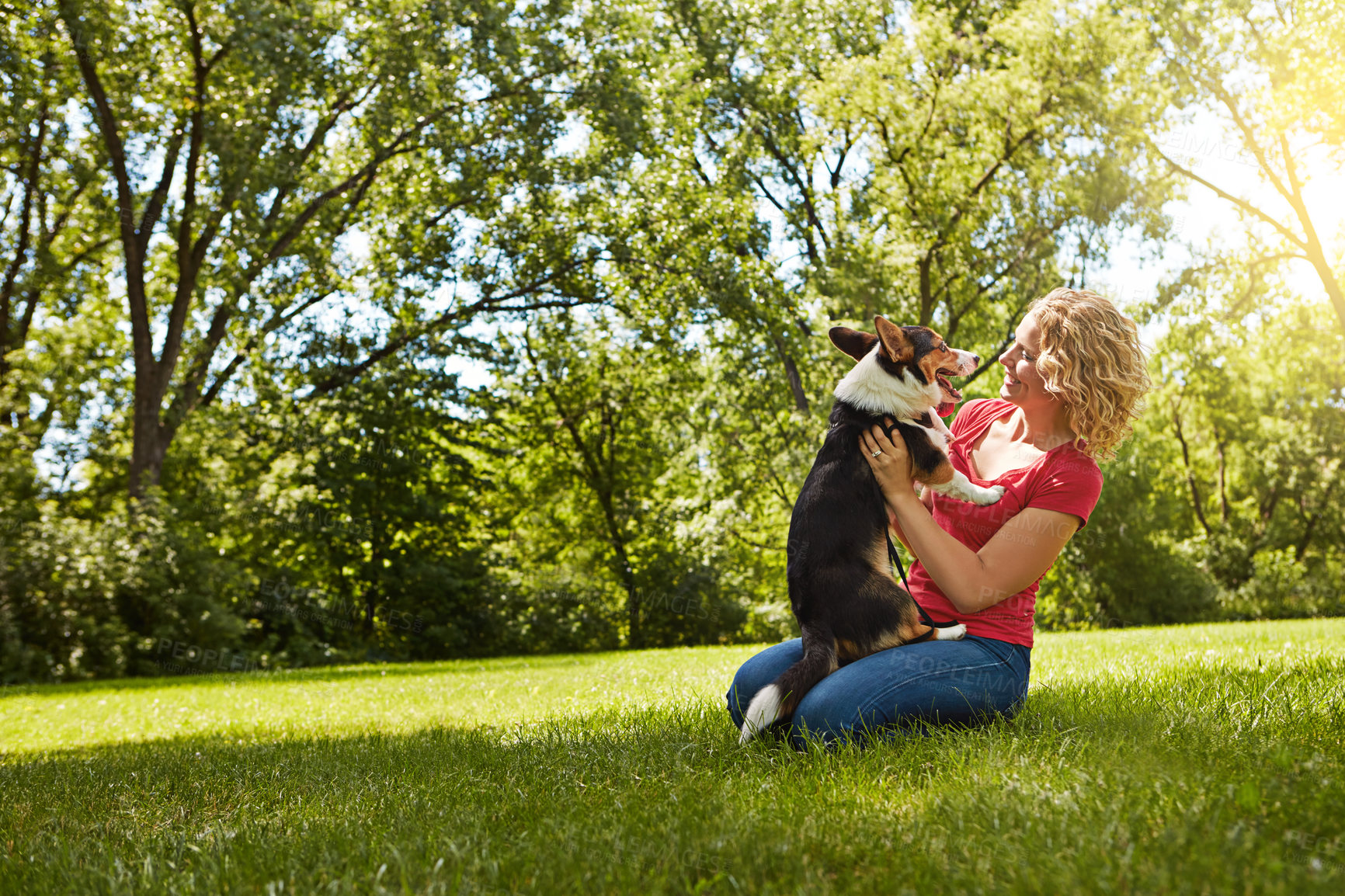 Buy stock photo Shot of a young woman bonding with her dog in the park