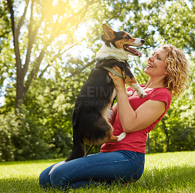 Buy stock photo Shot of a young woman bonding with her dog in the park