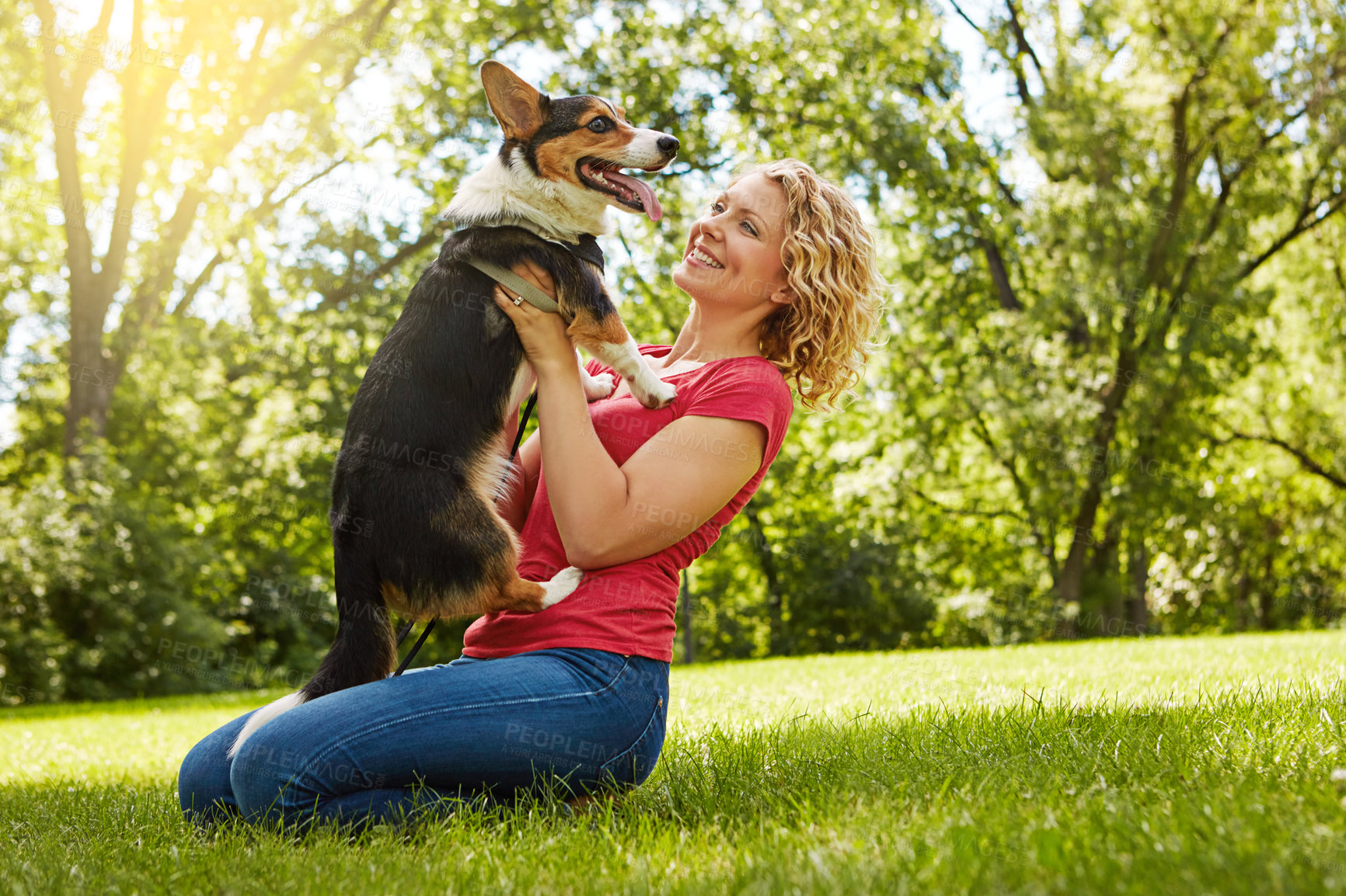 Buy stock photo Shot of a young woman bonding with her dog in the park