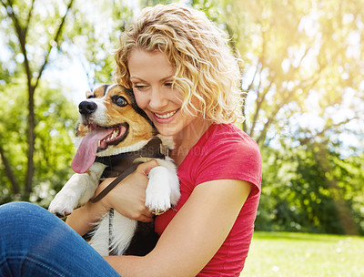 Buy stock photo Shot of a young woman bonding with her dog in the park