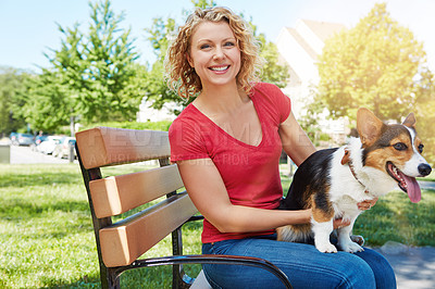 Buy stock photo Shot of a young woman bonding with her dog in the park