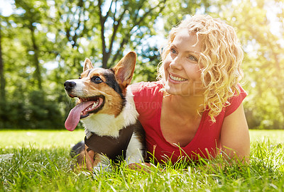 Buy stock photo Shot of a young woman bonding with her dog in the park