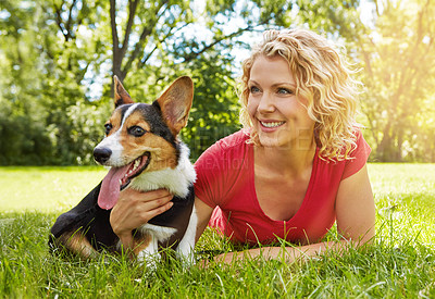 Buy stock photo Shot of a young woman bonding with her dog in the park