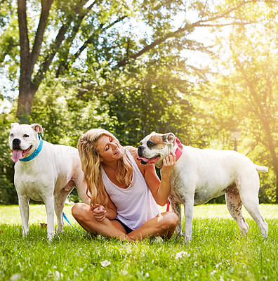 Buy stock photo Shot of a young woman with her two dogs at the park