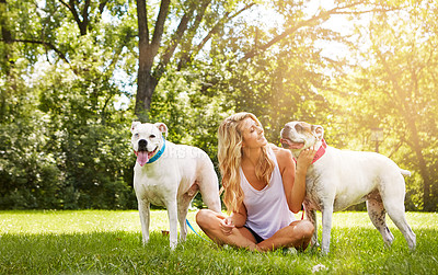 Buy stock photo Shot of a young woman with her two dogs at the park