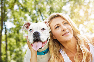 Buy stock photo Shot of a young woman spending time with her dog at the park