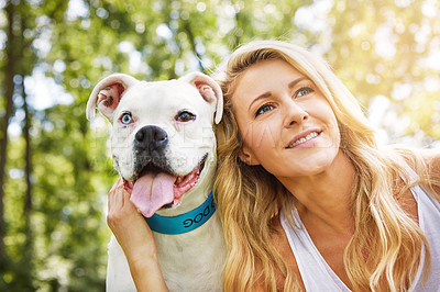 Buy stock photo Shot of a young woman spending time with her dog at the park