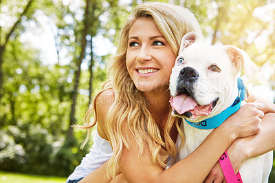 Buy stock photo Shot of a young woman spending time with her dog at the park