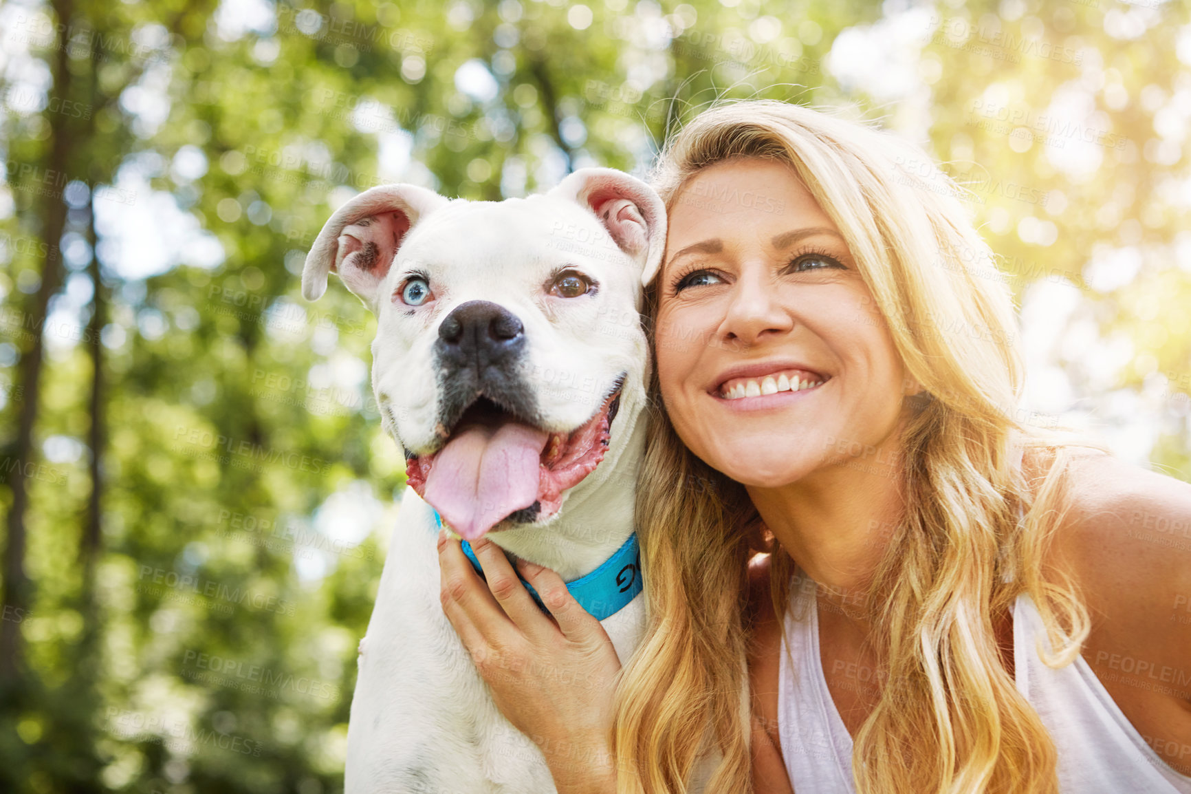 Buy stock photo Shot of a young woman spending time with her dog at the park