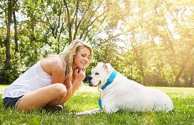 Buy stock photo Shot of a young woman spending time with her dog at the park