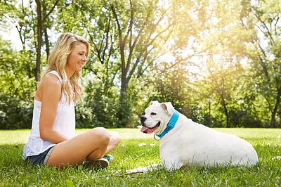 Buy stock photo Shot of a young woman spending time with her dog at the park