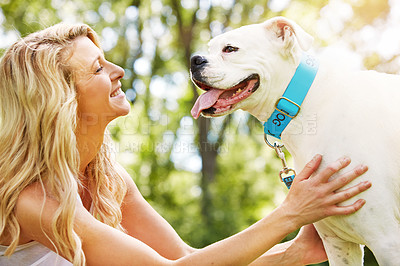 Buy stock photo Shot of a young woman spending time with her dog at the park