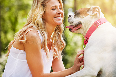 Buy stock photo Shot of a young woman spending time with her dog at the park