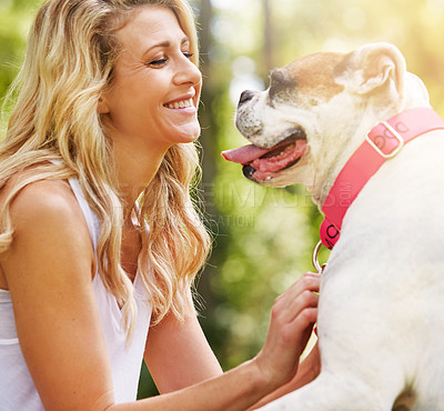 Buy stock photo Shot of a young woman spending time with her dog at the park