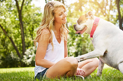 Buy stock photo Shot of a young woman spending time with her dog at the park