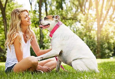 Buy stock photo Shot of a young woman spending time with her dog at the park