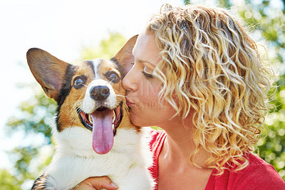 Buy stock photo Shot of a young woman bonding with her dog in the park