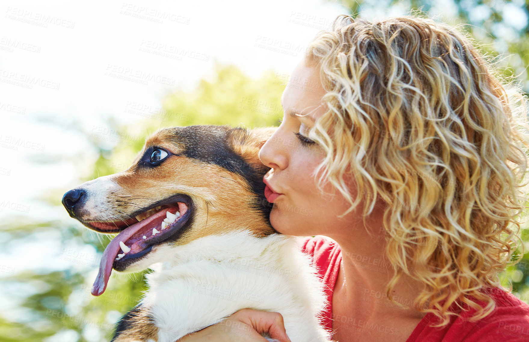 Buy stock photo Shot of a young woman bonding with her dog in the park