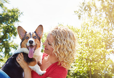 Buy stock photo Shot of a young woman bonding with her dog in the park