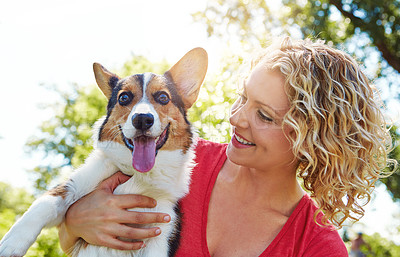 Buy stock photo Shot of a young woman bonding with her dog in the park