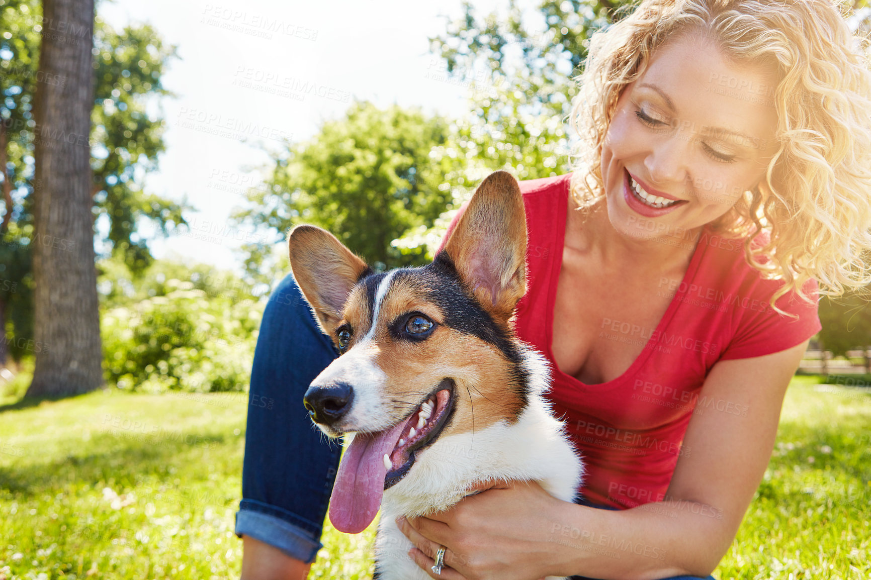 Buy stock photo Shot of a young woman bonding with her dog in the park