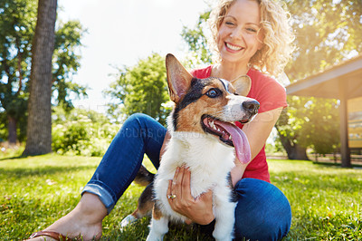 Buy stock photo Shot of a young woman bonding with her dog in the park