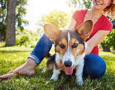 Buy stock photo Shot of a young woman bonding with her dog in the park