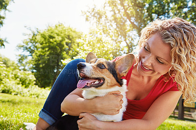 Buy stock photo Shot of a young woman bonding with her dog in the park