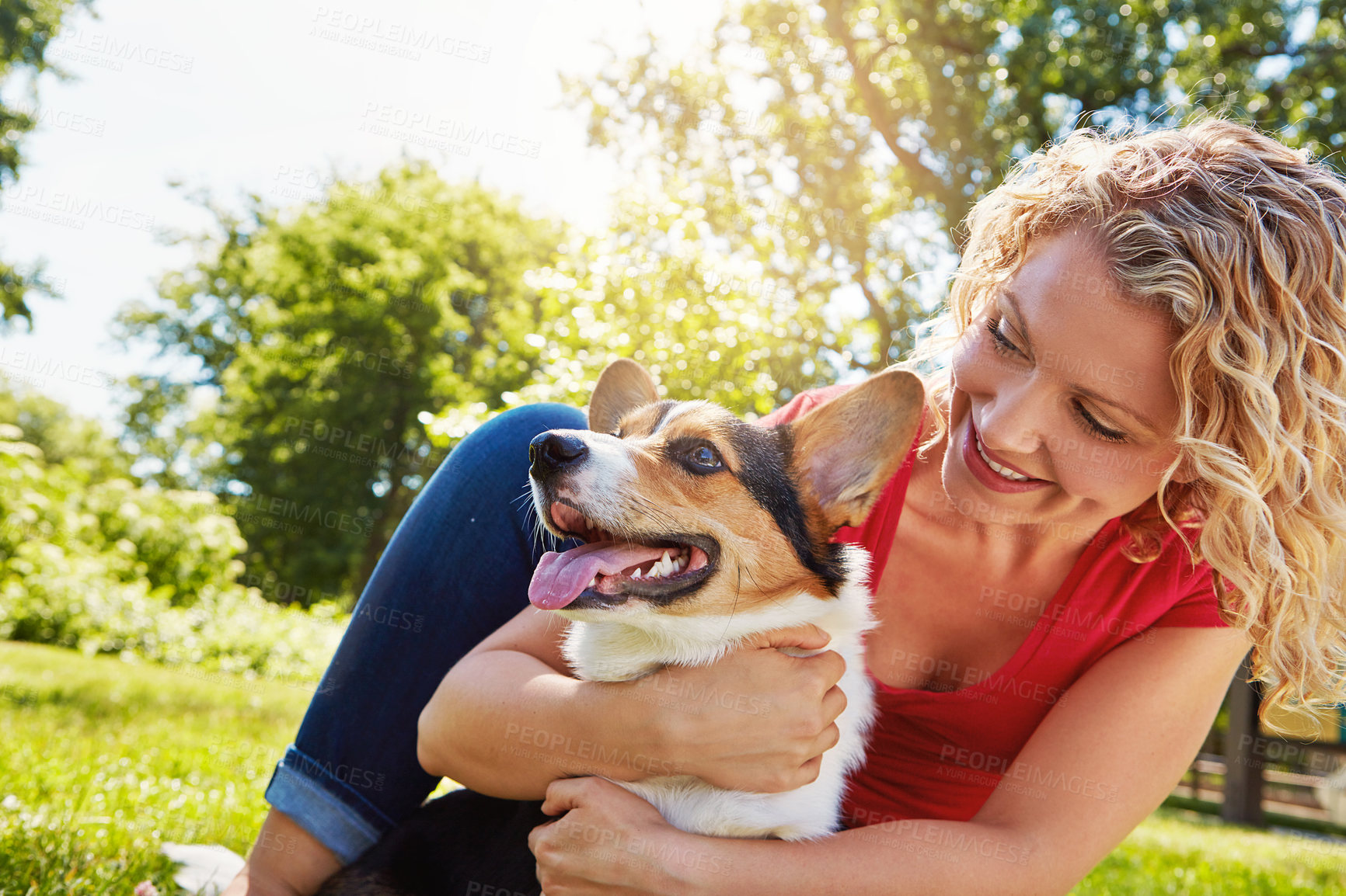 Buy stock photo Shot of a young woman bonding with her dog in the park