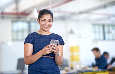 Buy stock photo Portrait of an attractive young businesswoman using her cellphone in the office