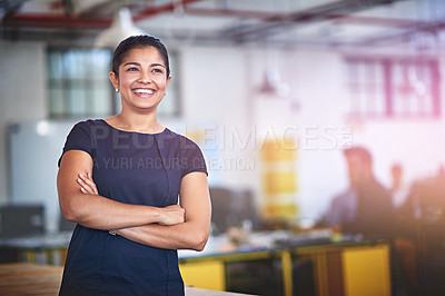 Buy stock photo Shot of an attractive young businesswoman standing with her arms folded in the office