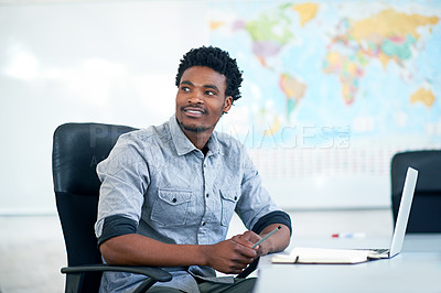 Buy stock photo Shot of a handsome young businessman taking notes in his office