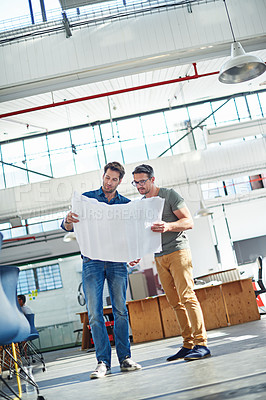 Buy stock photo Shot of two architects looking at blueprints together