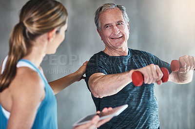 Buy stock photo Shot of a senior man using weights with the help of a physical therapist