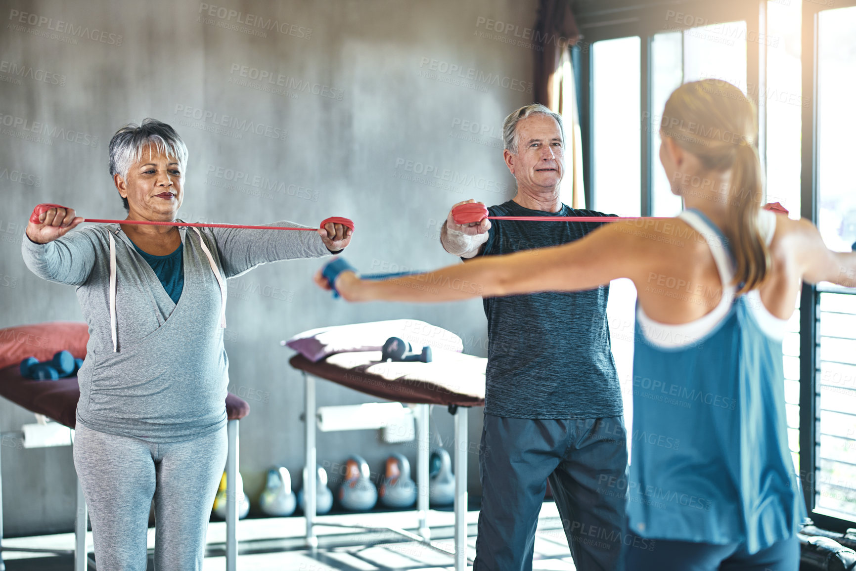 Buy stock photo Stretching band, support and senior people in physical therapy for help with muscle training by physiotherapist. Exercise, workout and strength progress of mature clients in wellness class or gym