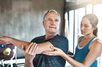 Buy stock photo Shot of a senior man working out with the help of an instructor