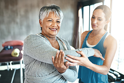 Buy stock photo Stretching, support and old woman with personal trainer for fitness, wellness or rehabilitation. Health, workout or retirement with senior patient and female trainer in gym for arm warm up training