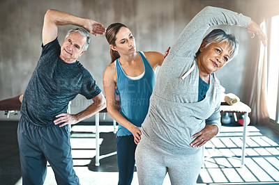 Buy stock photo Stretching, helping and senior people with personal trainer in class for fitness, wellness or rehabilitation. Health coach, workout or retirement with elderly patient, man or female in gym warm up