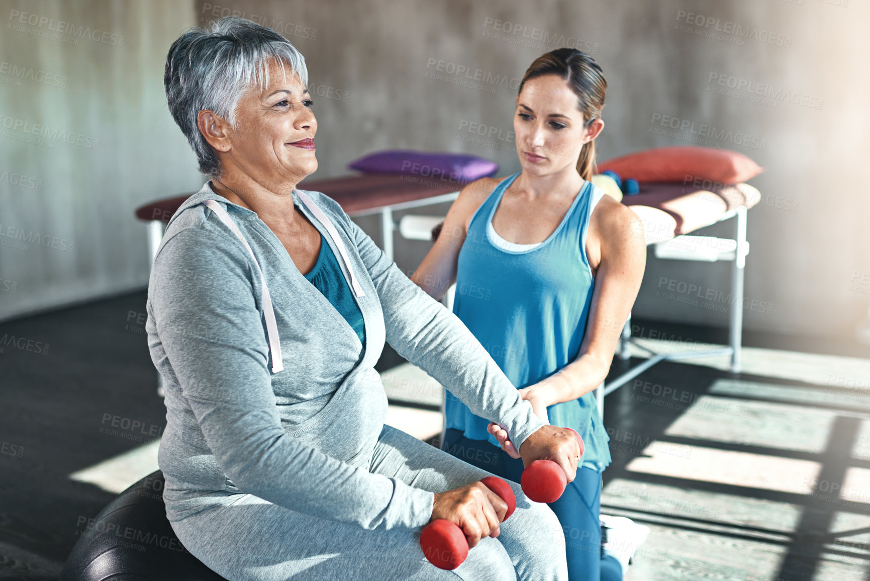 Buy stock photo Old woman, physiotherapy and dumbbell exercise or rehabilitation for injury training, joint pain or inflammation. Senior person, arthritis and muscle mobility on fitness ball, recovery or workout