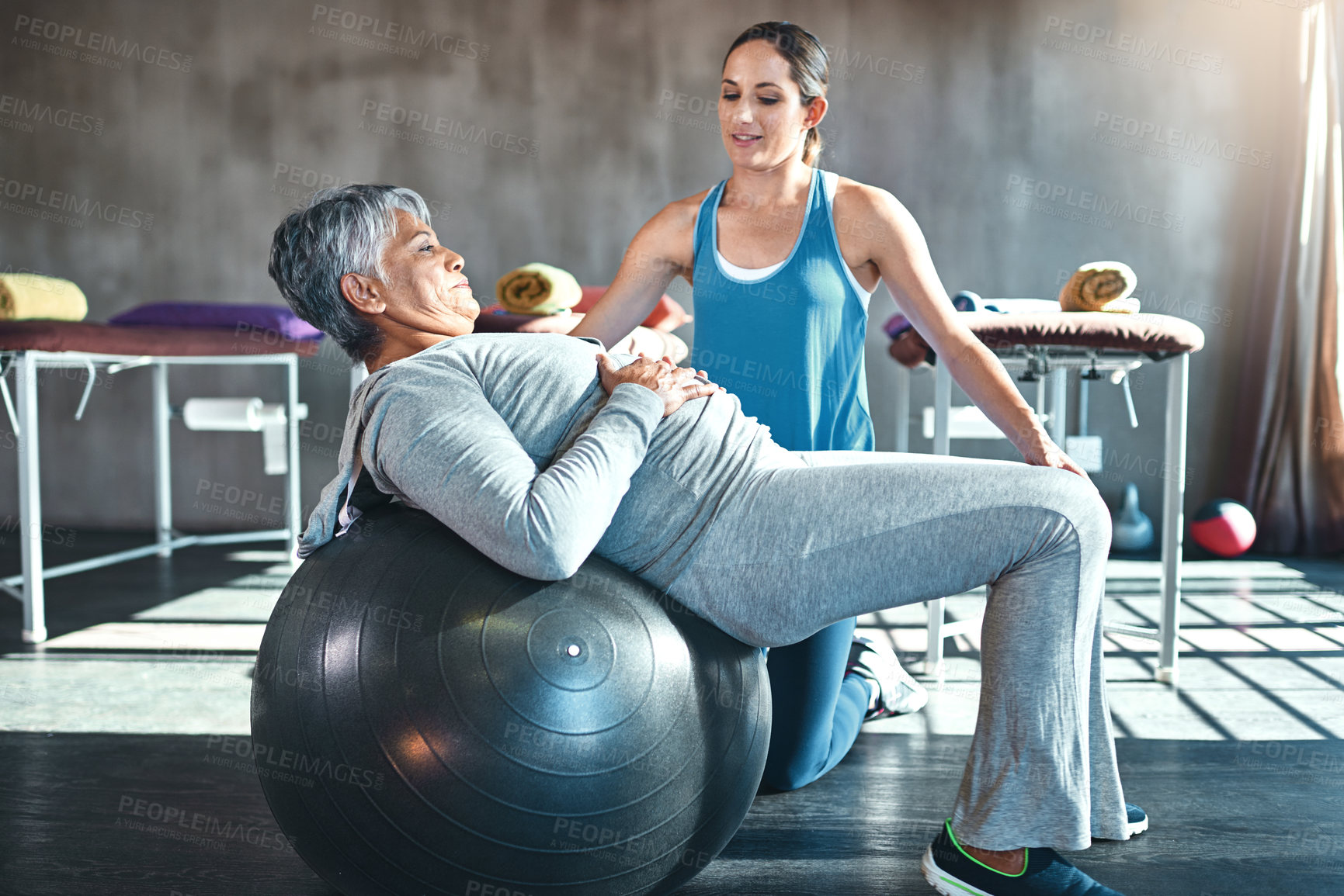 Buy stock photo Stretching, physiotherapist and senior woman with ball in clinic for physiotherapy, support or exercise. Wellness, healthcare worker and elderly patient for balance, recovery or rehabilitation