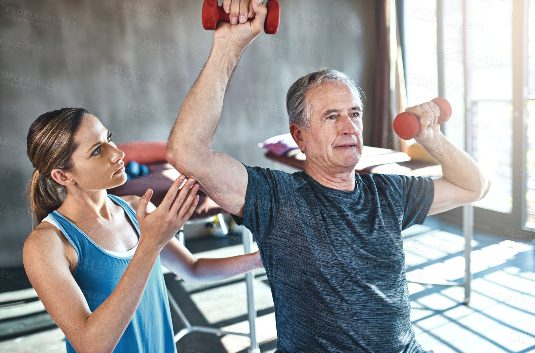Buy stock photo Elderly man, physiotherapist and workout with dumbbell in clinic for rehabilitation, support or exercise. Fitness, female coach and senior patient on ball for help, balance strength or physiotherapy