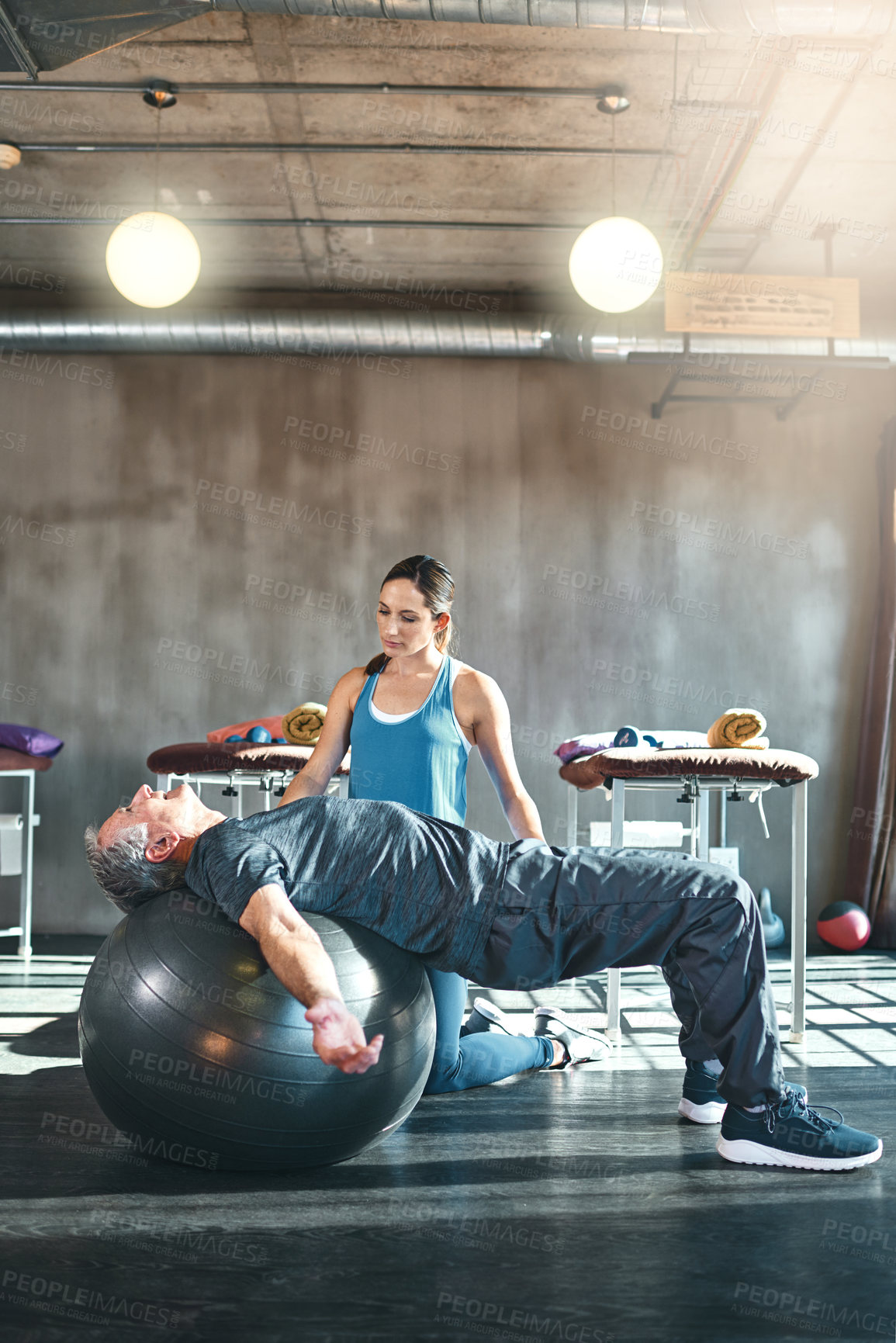 Buy stock photo Shot of a senior man working out with his physiotherapist