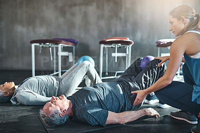 Buy stock photo Shot of two seniors working out with a physiotherapist