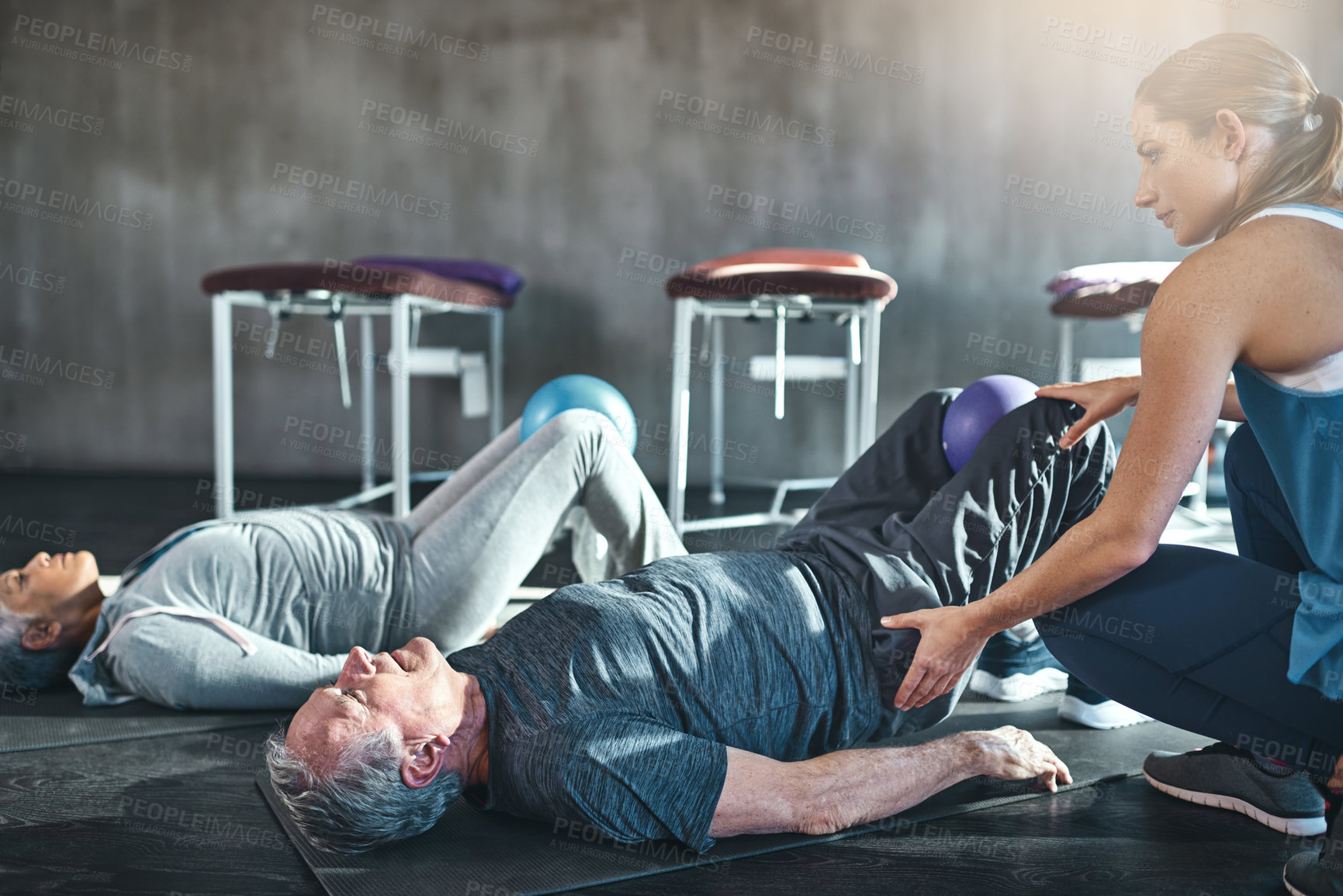 Buy stock photo Woman, senior couple and stretching in gym for health, wellness and exercise. Female physiotherapist, old people and equipment in fitness centre for retirement, rehabilitation and physical therapy