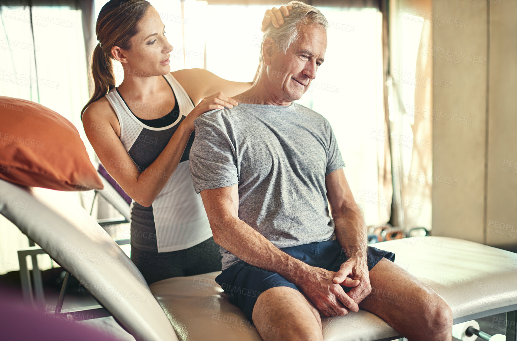 Buy stock photo Shot of a senior man being treated by a physiotherapist